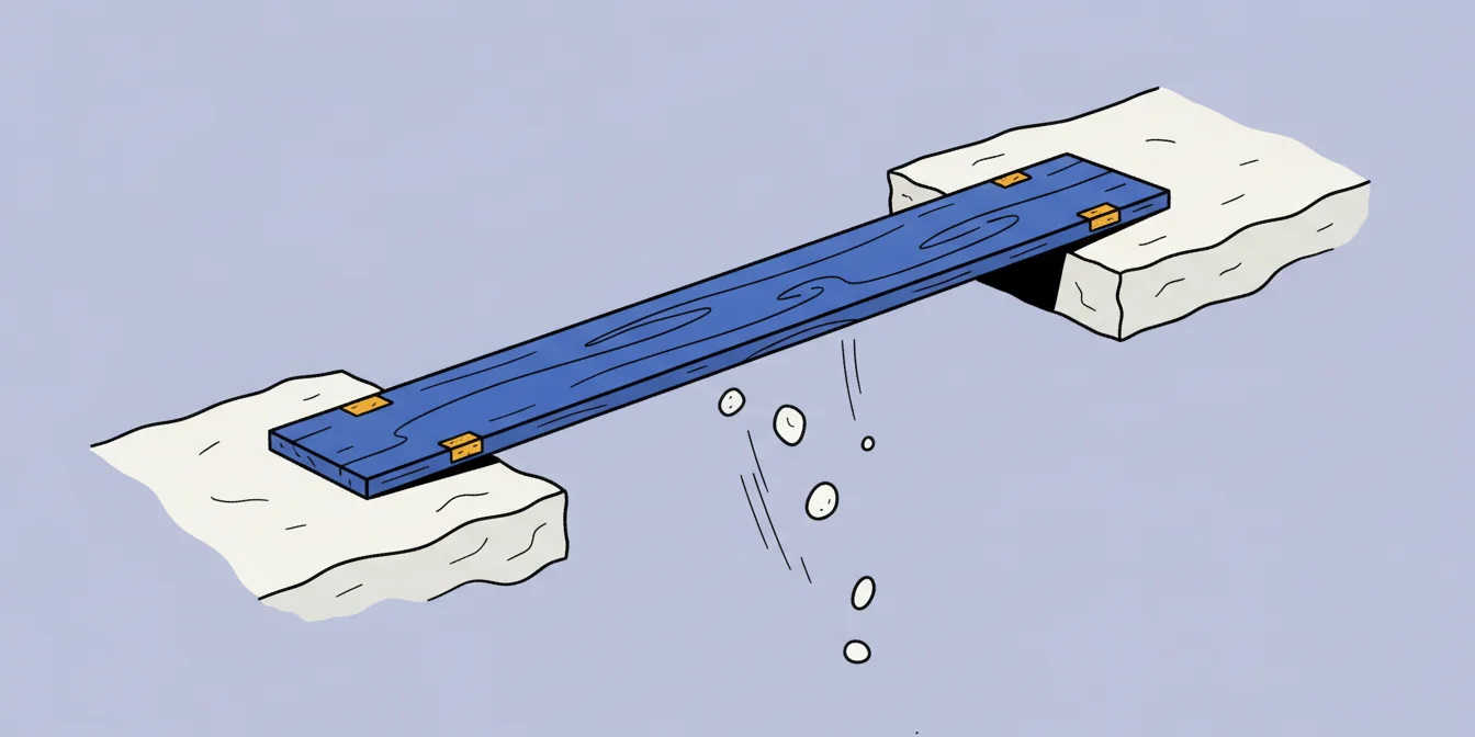 A single plank laid across the gap between two stone ledges of different heights, with pebbles falling into the space beneath it